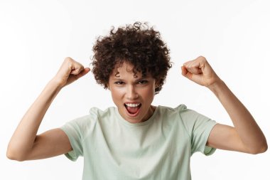 Genç kıvırcık kadın çığlık atarken kazanan jest beyaz arka planda izole edildi