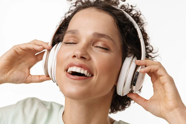 Joven Rizada Risueña Escuchando Música Con Auriculares Aislados Sobre Fondo — Foto de Stock