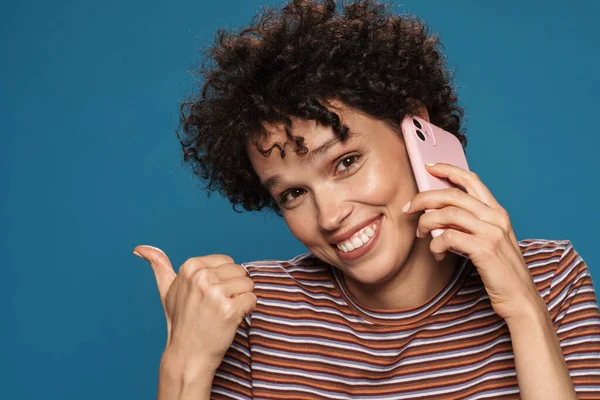 Молодая Улыбающаяся Женщина Указывая Пальцем Сторону Разговаривая Мобильному Телефону Изолированы — стоковое фото
