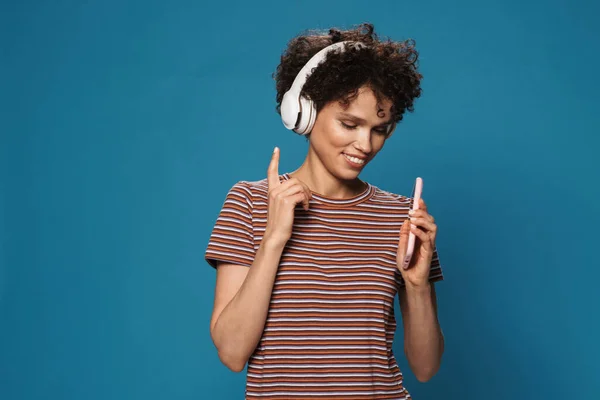 Mulher Sorridente Fones Ouvido Usando Celular Apontando Dedo Para Cima — Fotografia de Stock