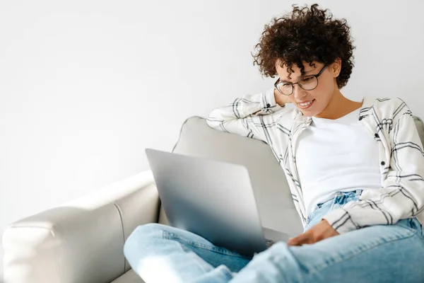 Ung Lockig Kvinna Ler Och Använder Laptop När Sitter Soffan — Stockfoto