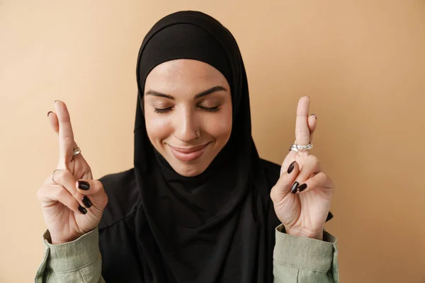 一个积极的穆斯林妇女站在橙色工作室里 闭上眼睛做祷告的肖像 — 图库照片
