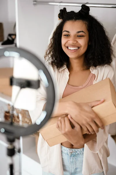 Happy Young African Woman Influencer Unpacking Parcel Standing Front Camera — Stok Foto