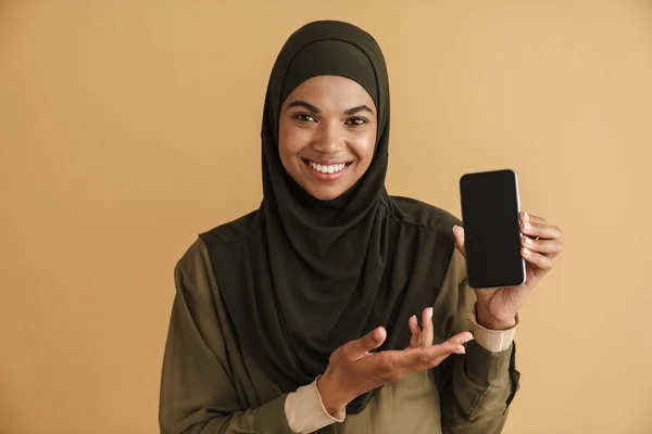 Чорна Мусульманка Хіджабі Посміхається Показує Мобільний Телефон Ізольовано Бежевому Фоні — стокове фото