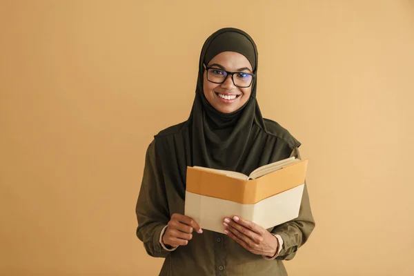 Schwarze Muslimische Frau Hidschab Lächelt Während Sie Buch Auf Beigem — Stockfoto