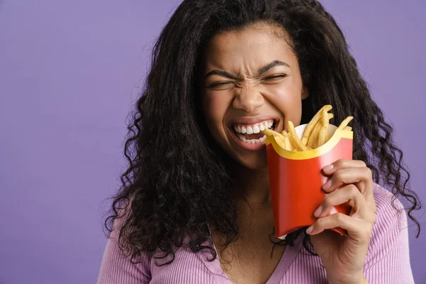 Jong Zwart Vrouw Glimlachen Terwijl Eten Frans Frietjes Geïsoleerd Paars — Stockfoto