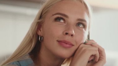 Güzel, rüya gören bir kadının yakın çekim görüntüsü kameraya bakıyor.