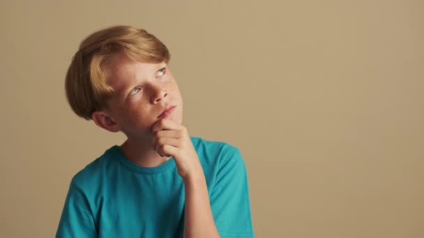 Przystojny Chłopiec Myśli Patrząc Bok Odizolowany Beżowego Tła Studio — Wideo stockowe