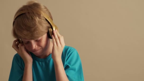 Happy Little Boy Listening Music Using Headphones Isolated Beige Background — Stock Video