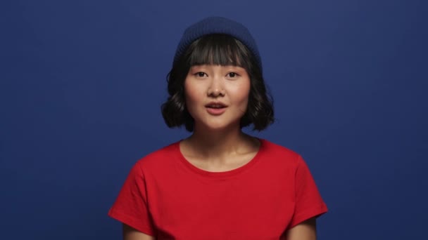 Gülümseyen Mutlu Asyalı Bir Kadın Stüdyodaki Mavi Duvarın Ardında Mutlu — Stok video
