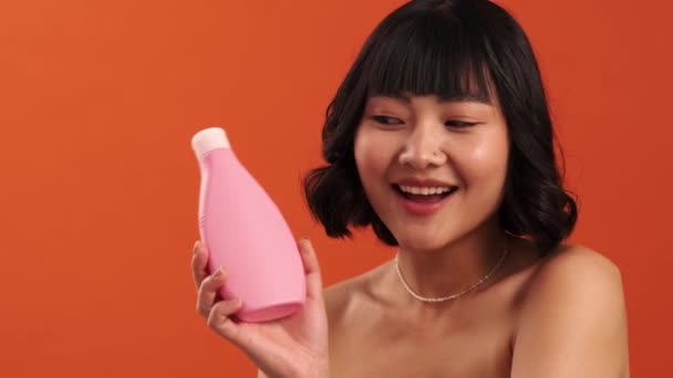 Una Vista Cerca Una Sonriente Mujer Asiática Semidesnuda Muestra Producto — Vídeos de Stock
