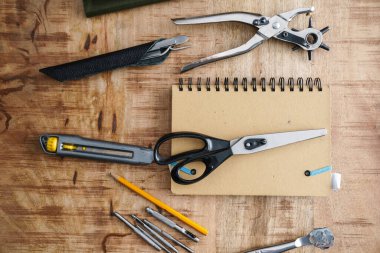 Alet edevat ve defter kapalı bir masada duruyor.