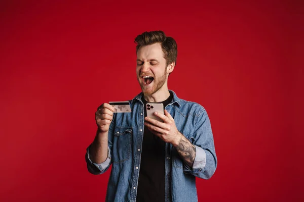 Jovem Sorridente Feliz Roupas Casuais Sobre Fundo Parede Vermelha Segurando — Fotografia de Stock