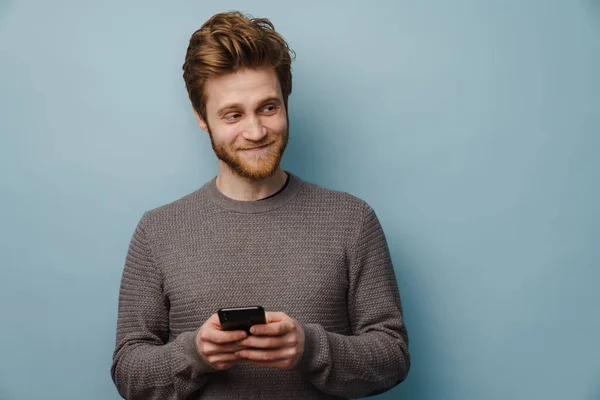 Sakallı Beyaz Kızıl Adam Gülümsüyor Mavi Arka Planda Cep Telefonu — Stok fotoğraf