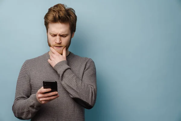 White Ginger Man Beard Frowning Using Mobile Phone Isolated Blue — Stock Photo, Image