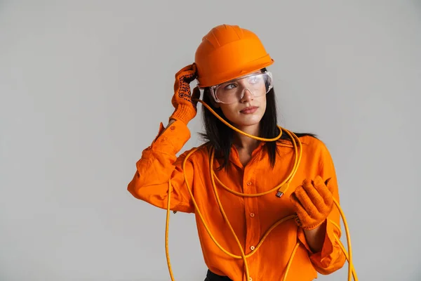 Güvenlik Gözlüklü Kasklı Genç Esmer Kadın Gri Arka Planda Kablo — Stok fotoğraf