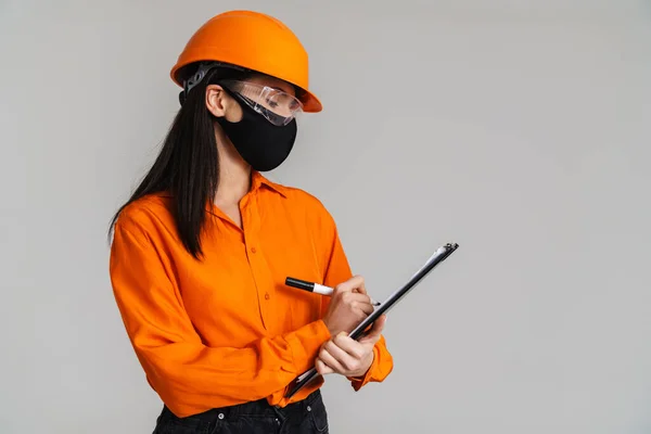 Güvenlik Gözlüklü Yüz Maskeli Genç Bir Kadın Gri Arka Planda — Stok fotoğraf