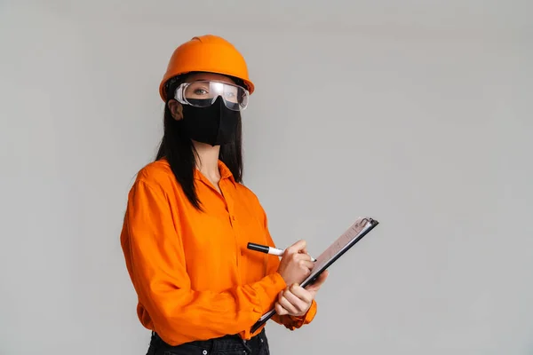 Güvenlik Gözlüklü Yüz Maskeli Genç Bir Kadın Gri Arka Planda — Stok fotoğraf