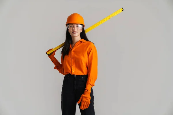 Jonge Vrouw Veiligheidsbril Helm Poseren Met Bouwgereedschap Geïsoleerd Grijze Achtergrond — Stockfoto