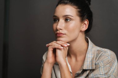 Genç esmer kadın poz veriyor ve içeri bakıyor.