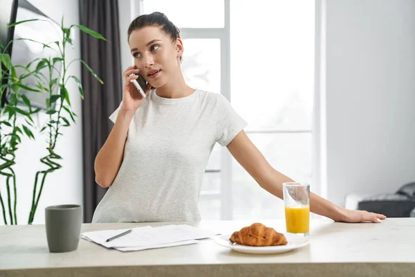Европейская Молодая Женщина Разговаривает Мобильному Телефону Завтракая Кухне Дома — стоковое фото
