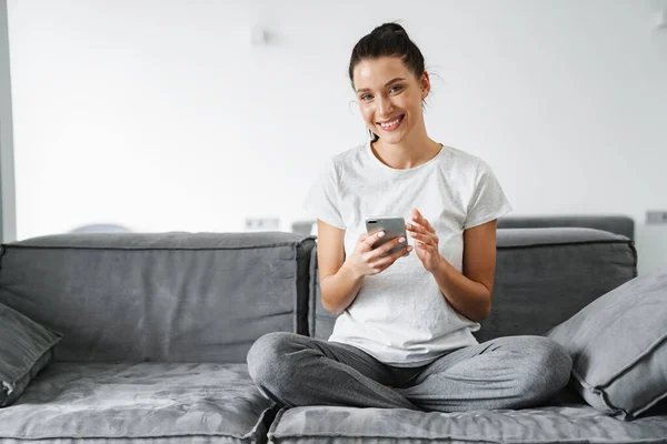 Europeu Sorrindo Mulher Usando Telefone Celular Enquanto Sentado Sofá Casa — Fotografia de Stock