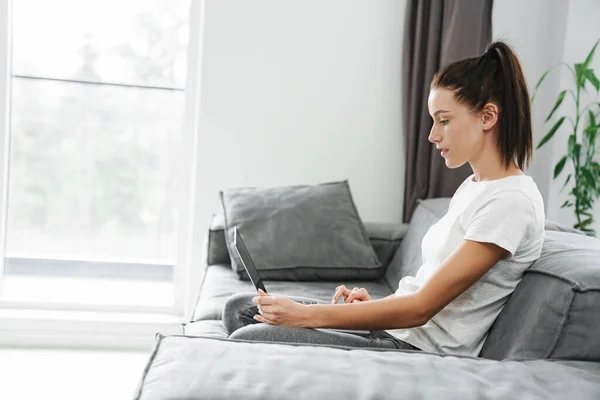 유럽의 여성은 집에서 소파에 노트북을 사용하는 — 스톡 사진