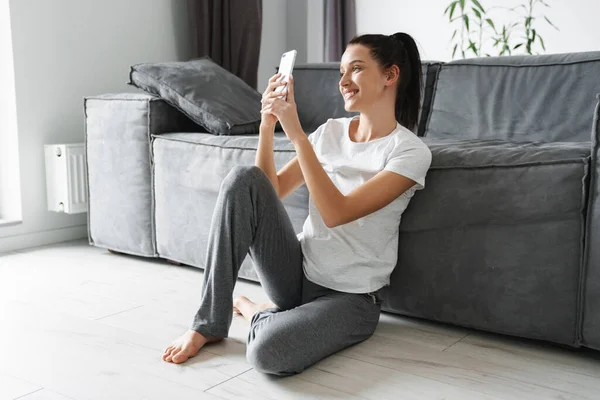 Avrupa Dan Gülümseyen Kadın Evde Otururken Cep Telefonu Kullanıyor — Stok fotoğraf