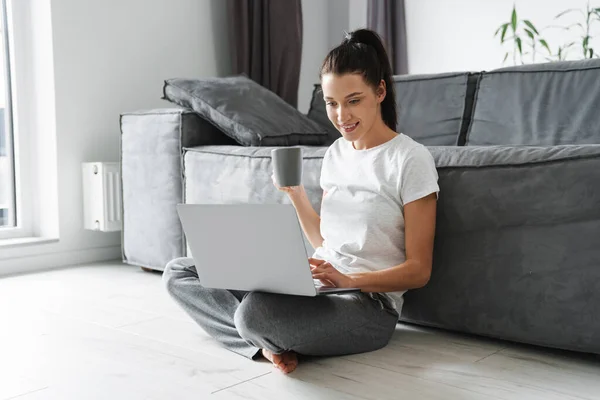 Donna Sorridente Bere Caffè Utilizzando Computer Portatile Mentre Seduto Sul — Foto Stock