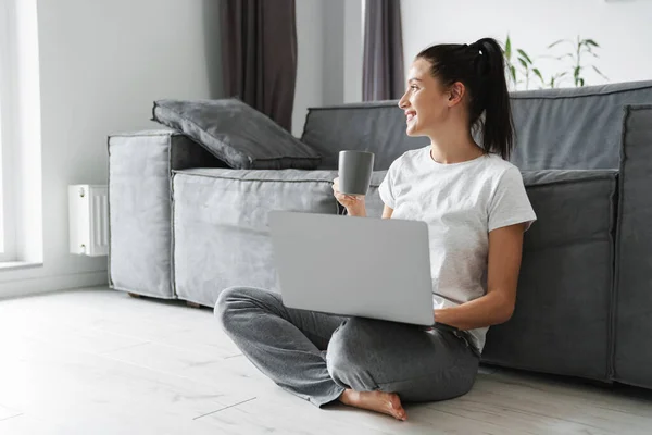 Donna Sorridente Bere Caffè Utilizzando Computer Portatile Mentre Seduto Sul — Foto Stock