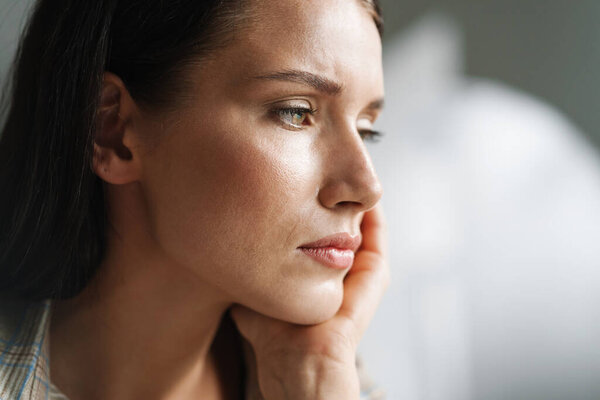 Young brunette woman posing and looking aside indoors