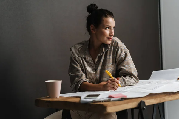 Joven Morena Trabajando Con Dibujos Mientras Está Sentada Escritorio Oficina — Foto de Stock