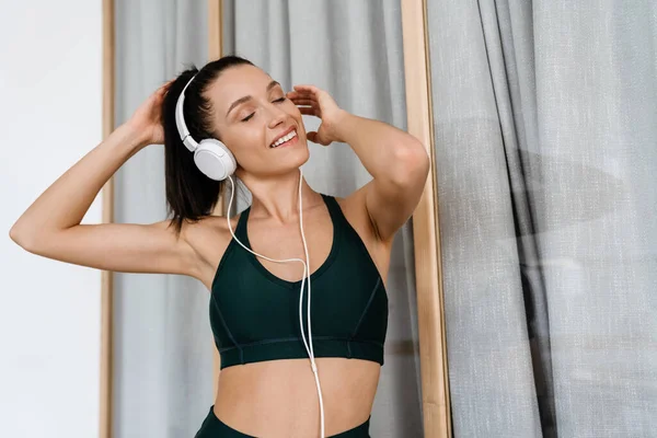 Mujer Morena Blanca Escuchando Música Con Auriculares Mientras Hace Ejercicio — Foto de Stock