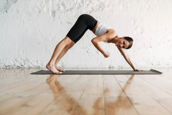 Joven Delgada Morena Fitness Mujer Estirándose Una Alfombra Deportiva Lado — Foto de Stock