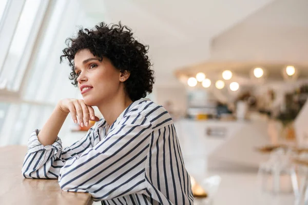 Beautiful Pleased Curly Woman Smiling Camera While Sitting Cafe — Stock Photo, Image