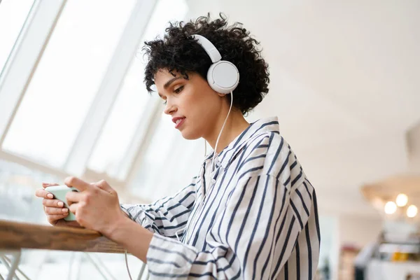 Mulher Focada Agradável Fones Ouvido Usando Telefone Celular Enquanto Sentado — Fotografia de Stock