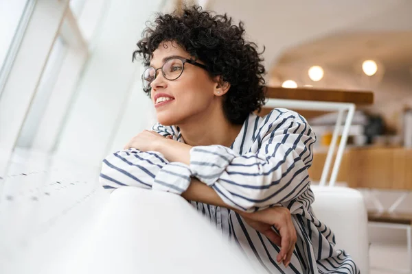 Mooie Gelukkig Vrouw Bril Glimlachen Terwijl Zitten Bank Cafe — Stockfoto