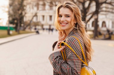 Gülümseyen sarışın genç bir kadını yakından çek.