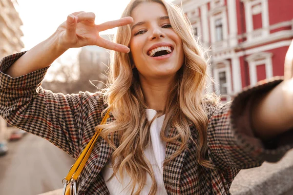 Sonriente Joven Rubia Tomando Una Selfie Mientras Camina Una Calle —  Fotos de Stock