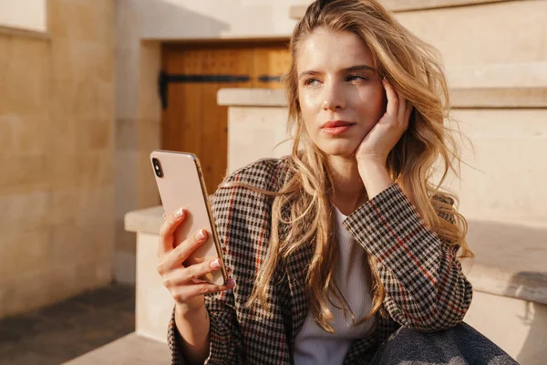 Blond Ung Kvinna Som Håller Mobiltelefon Bär Casual Kläder Gata — Stockfoto