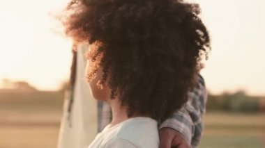 Küçük bir Afro-Amerikalı kızın yakın çekim görüntüsü annesiyle birlikte bir tarlada yürüyor.