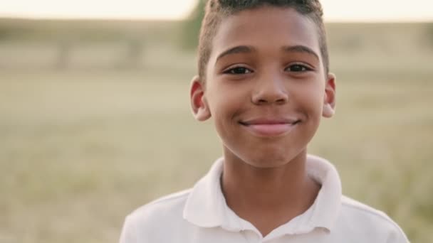 Ein Lächelnder Amerikanischer Junge Blickt Die Kamera Als Auf Der — Stockvideo