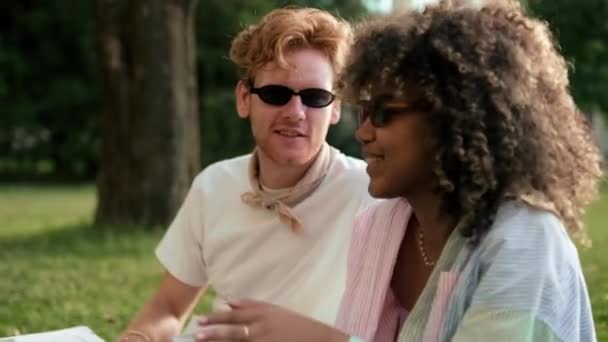 Smiling Friends Wearing Sunglasses Discussing Something While Sitting Grass Campus — Stock Video