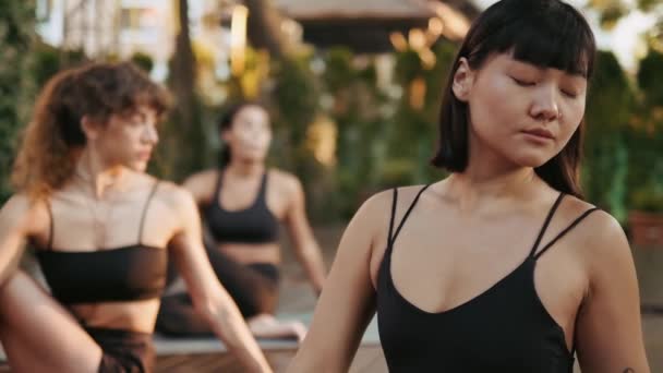 Una Coreana Haciendo Estiramientos Sentada Esterilla Yoga Afuera Con Grupo — Vídeo de stock