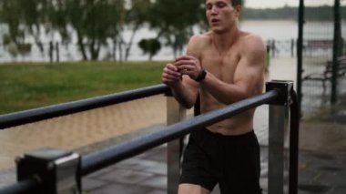 Çekici bir adam spor alanında antrenman yapıyor.