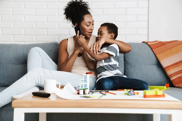 Mujer Negra Hablando Por Celular Mientras Abraza Hijo Casa — Foto de Stock