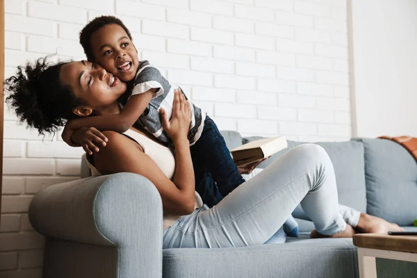 Negro Feliz Madre Hijo Abrazando Burlándose Mientras Está Sentado Sofá — Foto de Stock