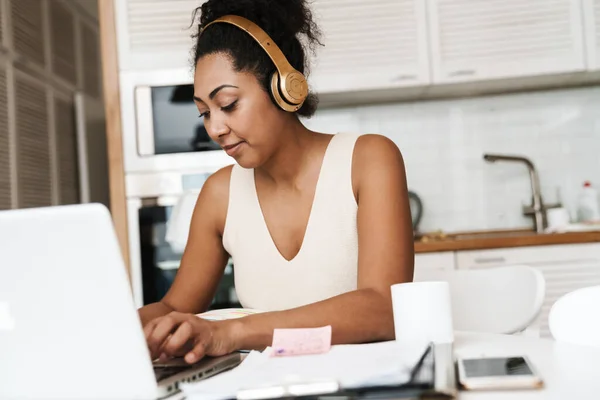 Zwart Vrouw Hoofdtelefoon Werken Met Laptop Terwijl Zitten Aan Tafel — Stockfoto