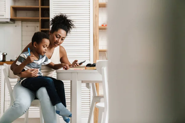 Negro Madre Hijo Escribiendo Usando Teléfono Móvil Mientras Están Sentados —  Fotos de Stock