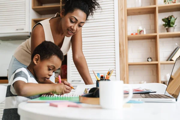 Nero Madre Utilizzando Laptop Mentre Fare Compiti Con Figlio Casa — Foto Stock